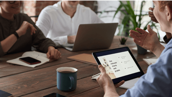 animate presentation ppt Photograph of 3 people gathered together talking about a report with a tablet