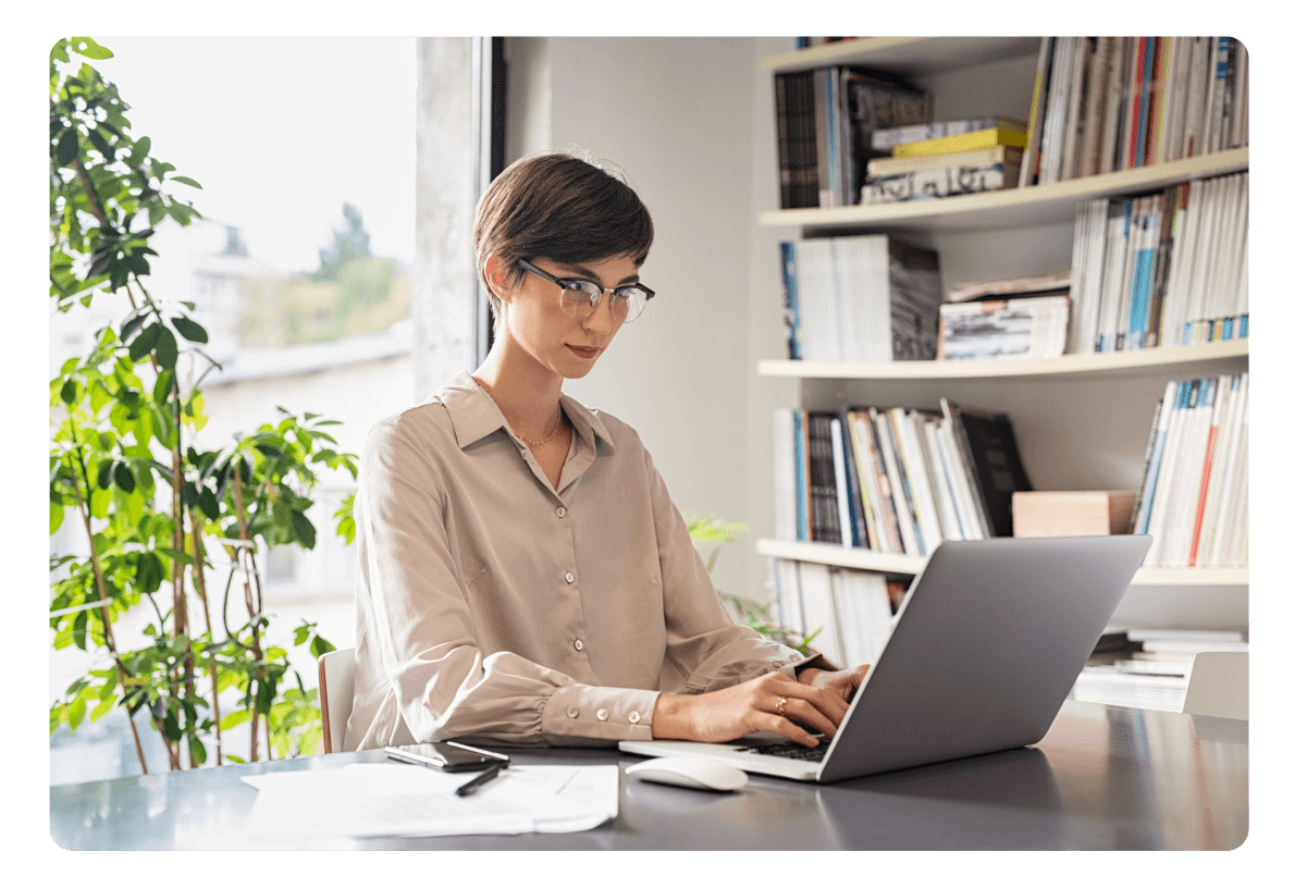 Uma garota sentada em um laptop criando um currículo