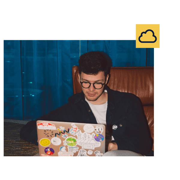 Boy sitting in front of his laptop with stickers, illustrating text explaining that Genially works in the cloud