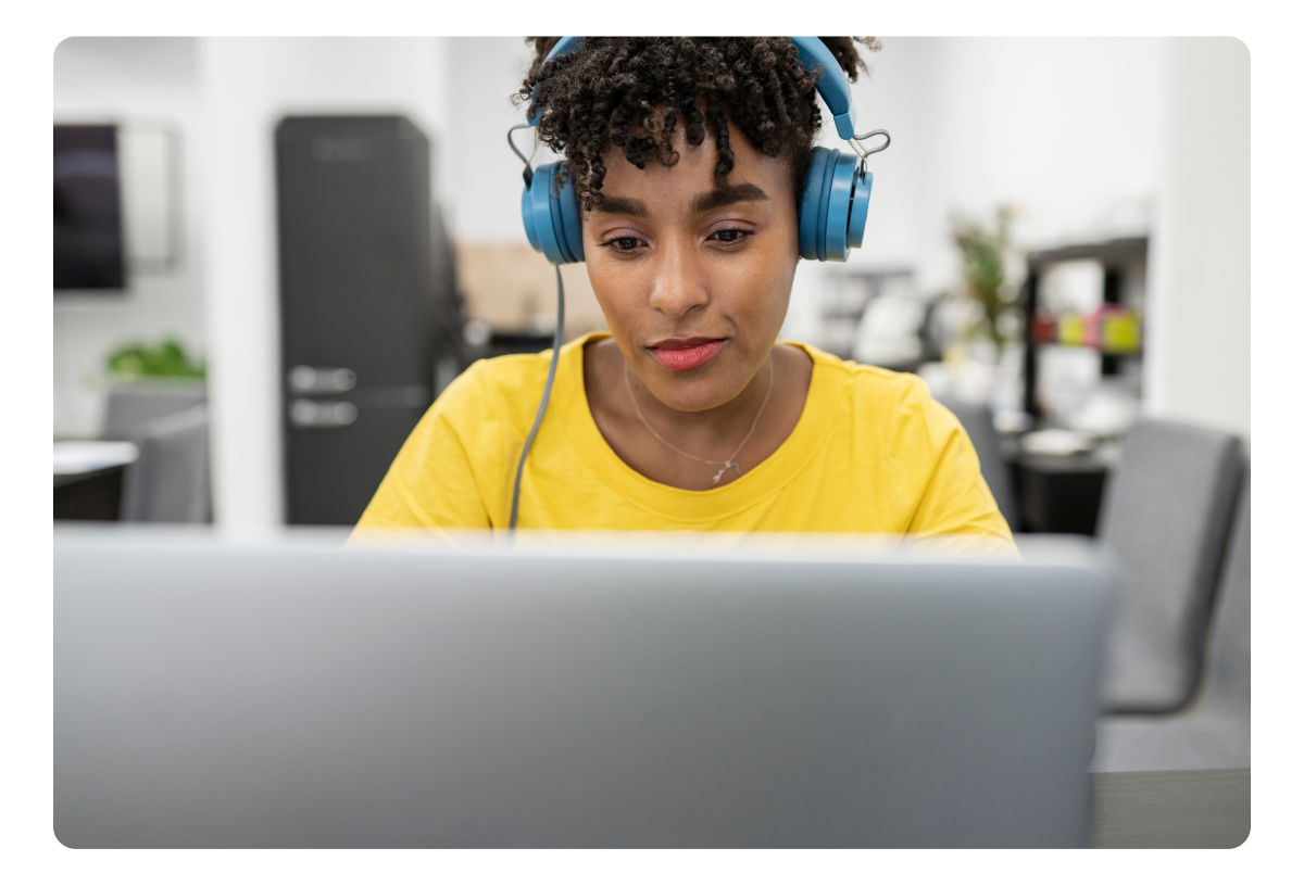 A student using a laptop with headphones for e-learning