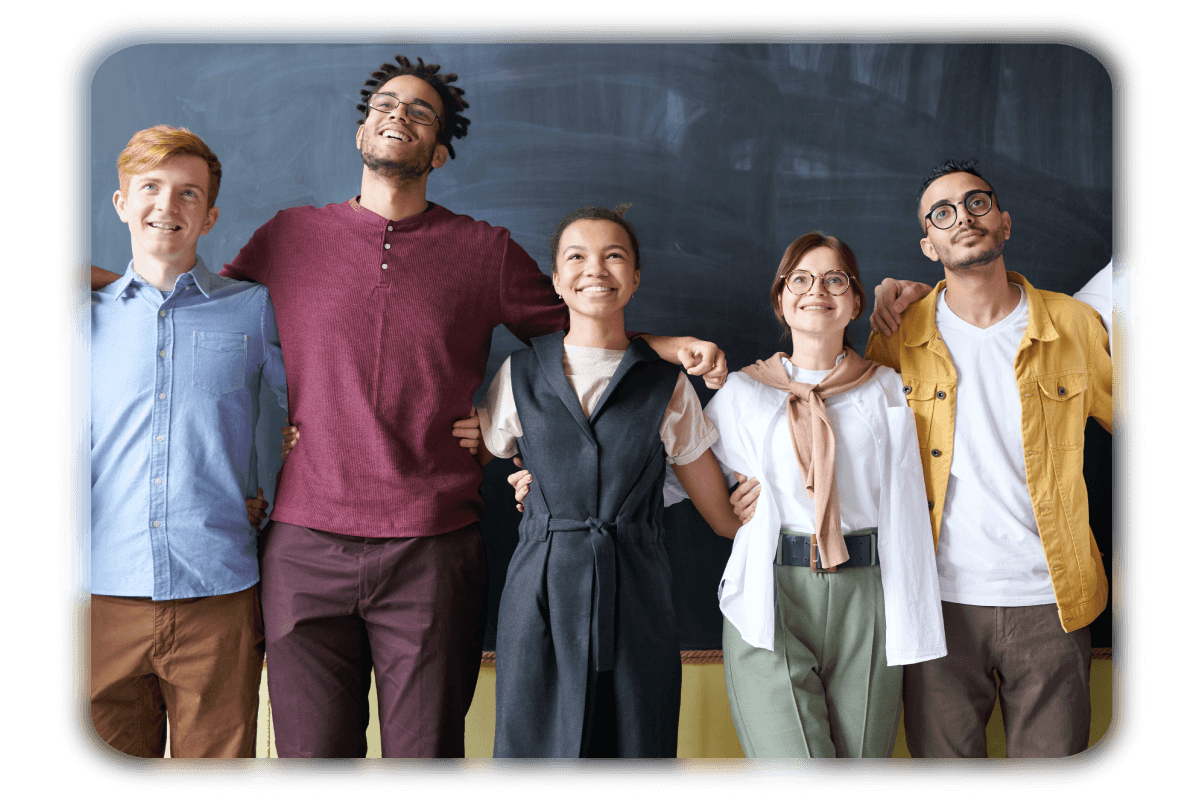 Students smiling and collaborating around a laptop at school